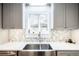 The kitchen area features a stainless steel sink with neutral colored tile backsplash and ample counter space at 6800 S Pennsylvania St, Centennial, CO 80122