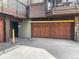 Attached garage with wooden doors and exterior stone and wood accents at 290 Broken Lance Dr # B104, Breckenridge, CO 80424