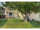 Tan house with a large tree and green grass at 19136 E Milan Cir, Aurora, CO 80013