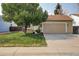 Tan house with attached garage and green lawn at 19136 E Milan Cir, Aurora, CO 80013