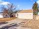 Attached garage with tan exterior and driveway at 19136 E Milan Cir, Aurora, CO 80013