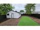 Backyard with detached garage with white siding and string lights, as well as artificial turf at 1409 S Clermont St, Denver, CO 80222