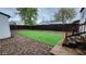 Fenced backyard with gravel, artificial turf, and stairs up to deck at 1409 S Clermont St, Denver, CO 80222