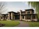 Striking modern home with stone and wood accents, large windows, and a curved driveway at 90 Meade Ln, Englewood, CO 80113