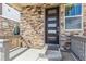 Close-up of a stylish front door with modern design, stone facade, and covered porch at 21761 E 7Th Ave, Aurora, CO 80018