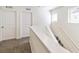 Upstairs hallway featuring carpet, two doors, and natural light from nearby windows at 21761 E 7Th Ave, Aurora, CO 80018
