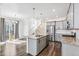 Well-lit kitchen with stainless steel appliances, gray cabinets, granite counters, and open to living area at 21761 E 7Th Ave, Aurora, CO 80018