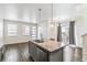 Kitchen island with granite countertops, double sink, and pendant lighting, open to living area at 21761 E 7Th Ave, Aurora, CO 80018