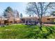 Expansive backyard with lush green grass, mature trees, and a charming patio area for outdoor gatherings at 10395 W 74Th Pl, Arvada, CO 80005