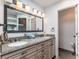 Bathroom with double vanity, granite countertops, and ornate mirror at 10395 W 74Th Pl, Arvada, CO 80005