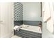 Relaxing bathroom features a soaking tub with navy blue subway tile surround at 10395 W 74Th Pl, Arvada, CO 80005