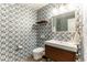 Stylish powder room features modern vanity, commode and unique blue patterned wallpaper at 10395 W 74Th Pl, Arvada, CO 80005