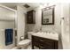 Cozy bathroom with a wooden vanity, framed mirror, shower stall, and decorative storage at 10395 W 74Th Pl, Arvada, CO 80005