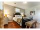 Charming bedroom features hardwood floors, a black bed frame, soft neutral tones, and a bench at 10395 W 74Th Pl, Arvada, CO 80005