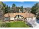 Stunning home featuring mature trees, lush landscaping, and a spacious deck perfect for outdoor living at 10395 W 74Th Pl, Arvada, CO 80005