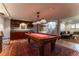 Large game room featuring a pool table, wet bar, and an adjacent staircase at 10395 W 74Th Pl, Arvada, CO 80005