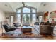 Bright living room featuring high ceilings, large windows, and a cozy seating area with a colorful rug at 10395 W 74Th Pl, Arvada, CO 80005