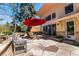 Beautiful outdoor patio with stone pavers, a red umbrella, and comfortable seating area at 10395 W 74Th Pl, Arvada, CO 80005