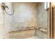 Luxurious shower features a built-in bench, designer tile, and modern fixtures at 10395 W 74Th Pl, Arvada, CO 80005