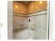 Modern shower with custom tile work, a built-in bench, and a sleek glass door at 10395 W 74Th Pl, Arvada, CO 80005