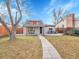 Charming home featuring a covered porch and a cozy patio area, set against a bright blue sky at 4787 S Grant St, Englewood, CO 80113