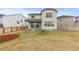 Spacious backyard with lawn, adjacent homes, and sliding glass door to covered patio at 13446 Amber Sky St, Parker, CO 80134