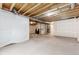 Unfinished basement with concrete floor, exposed beams, and white plastic vapor barrier at 13446 Amber Sky St, Parker, CO 80134