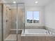 Bright bathroom with tile surround shower and separate soaking tub with large window at 13446 Amber Sky St, Parker, CO 80134