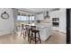 Bright kitchen features a quartz island, seating, stainless appliances, and sliding glass doors with a view at 13446 Amber Sky St, Parker, CO 80134