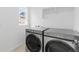Modern laundry room with Samsung front-load washer and dryer and built-in shelf at 13446 Amber Sky St, Parker, CO 80134