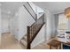 Staircase with wood railings and carpeted steps adjacent to a dining area with modern decor and natural light at 13446 Amber Sky St, Parker, CO 80134