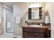 Bathroom featuring a single sink vanity with dark wood cabinets and a tiled shower at 1095 W 69Th Ave, Denver, CO 80221