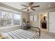 Inviting bedroom featuring large windows, a ceiling fan, and ensuite bath access at 1095 W 69Th Ave, Denver, CO 80221