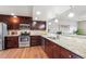 A kitchen featuring stainless appliances, granite countertops and dark wood cabinets at 1095 W 69Th Ave, Denver, CO 80221