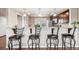 A kitchen area with a breakfast bar and granite countertops, featuring four barstools at 1095 W 69Th Ave, Denver, CO 80221