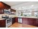 A kitchen featuring stainless appliances, granite countertops and dark wood cabinets at 1095 W 69Th Ave, Denver, CO 80221