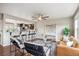 A living room with hardwood floors, a ceiling fan, and a seating area at 1095 W 69Th Ave, Denver, CO 80221