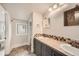 Bathroom featuring dual sinks, neutral tile, a window and a doorway to the toilet area at 519 S Gaylord St, Denver, CO 80209