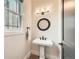 Elegant powder room featuring pedestal sink, bronze fixtures and a large window at 519 S Gaylord St, Denver, CO 80209