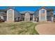 Well-maintained condo building with stone accents and lush green lawn under a clear blue sky at 3250 E 103Rd Pl # 805, Thornton, CO 80229