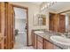 Bathroom featuring double sinks, granite counters, and wood cabinets at 8403 Homestake Ct, Larkspur, CO 80118