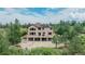 Home with a multi-tiered deck, perfect for entertaining, surrounded by trees at 8403 Homestake Ct, Larkspur, CO 80118