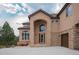 Exterior of a charming home with a stone archway and attached two-car garage at 8403 Homestake Ct, Larkspur, CO 80118