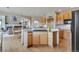 Open kitchen with wood cabinets, granite countertops, and a breakfast bar with adjacent dining area and living room at 8403 Homestake Ct, Larkspur, CO 80118