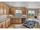 Well-lit kitchen boasts wood cabinetry, granite countertops, and scenic views from the window and sliding glass doors at 8403 Homestake Ct, Larkspur, CO 80118