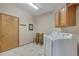 Functional laundry room featuring a washer, dryer, storage cabinets, and neutral tile flooring at 8403 Homestake Ct, Larkspur, CO 80118