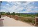 Wide patio showcasing wood railings with stone pillars, offering stunning views of the surrounding landscape and mountains at 8403 Homestake Ct, Larkspur, CO 80118