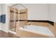 Well-lit bathroom featuring a soaking tub and glass-enclosed shower at 10152 Bluffmont Ln, Lone Tree, CO 80124