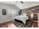 A primary bedroom with a wood accent wall, vaulted ceiling, and plantation shutters at 10152 Bluffmont Ln, Lone Tree, CO 80124