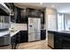 Bright kitchen with stainless steel refrigerator and black cabinets at 4090 Forever Cir, Castle Rock, CO 80109